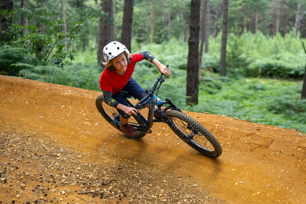 kid rides bike round corner