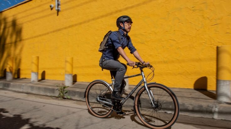 An image of a male cyclist riding a Marin Bikes bicycle in a city