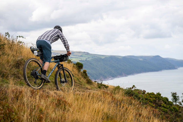 Man bikepacking on a coastal trail
