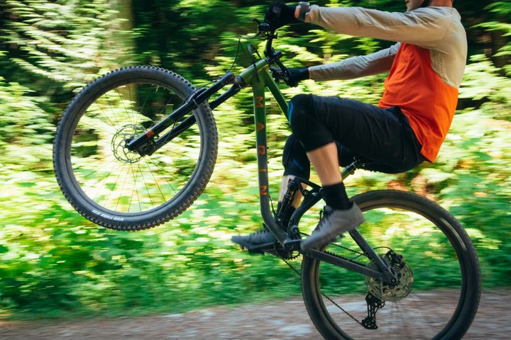 Man wheelies along a trail