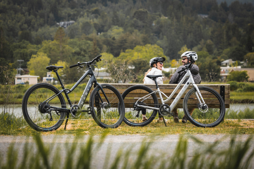A couple sit on a bench during an ebike ride