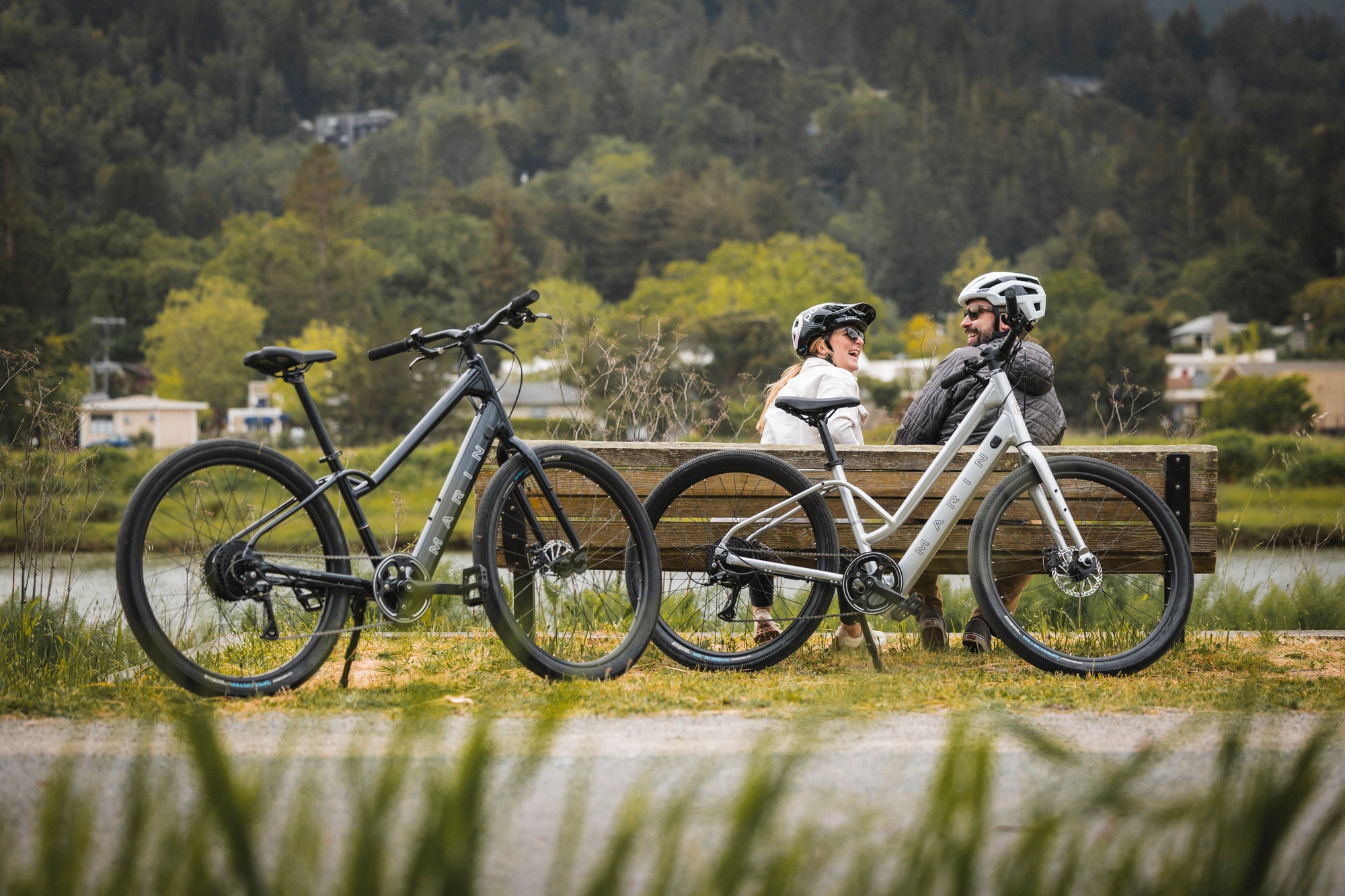 A couple sit on a bench during an ebike ride