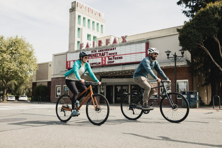 Couple ride past a cinema in Fairfax