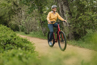Woman rides a bike along a woodland track