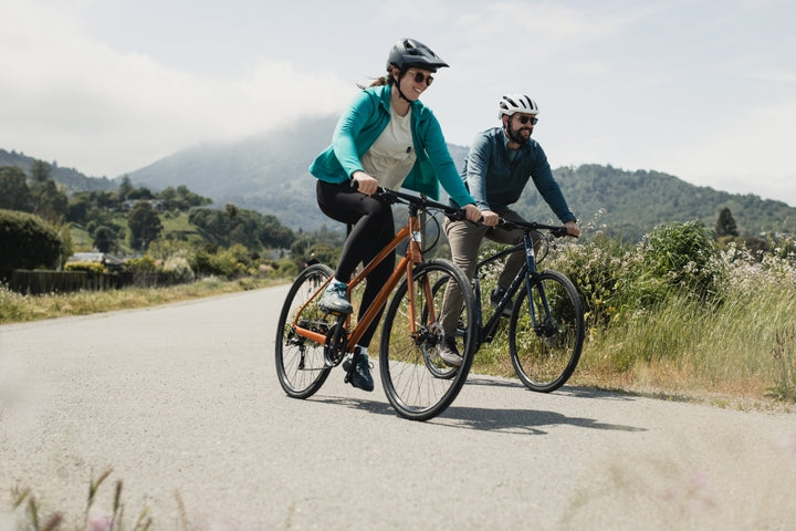 Couple ride bikes along a rural road
