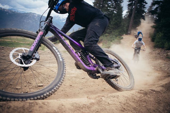 Group ride downhill bikes on a dusty trail