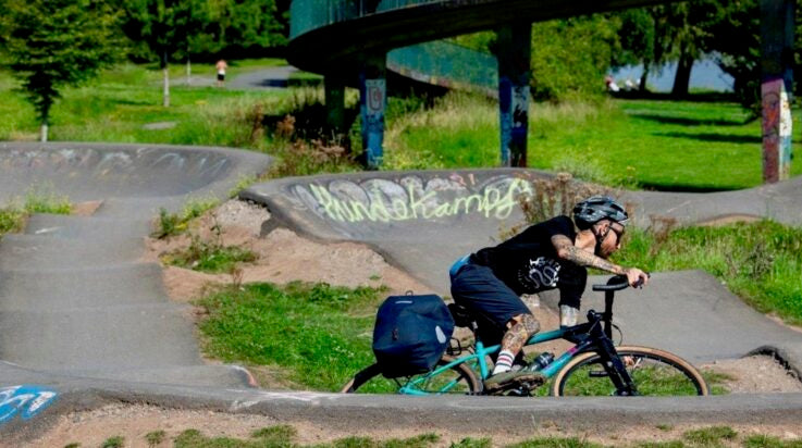 An image of a male cyclist riding an adventure/bike packing drop bar Marin Bikes bike on a pump track